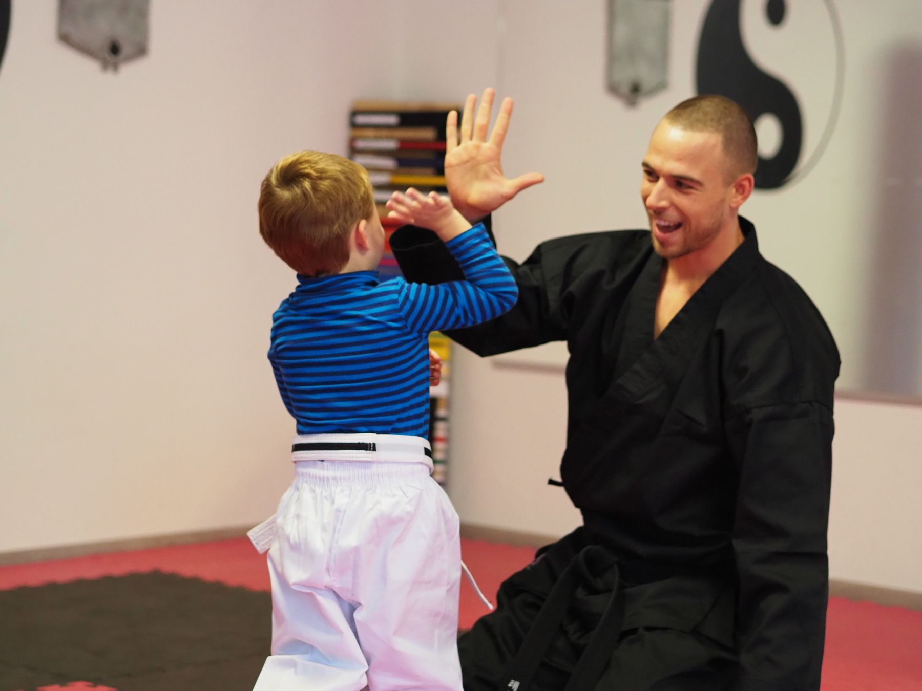 Daniel klatscht beim Kindertraining mit einem Jungen ab