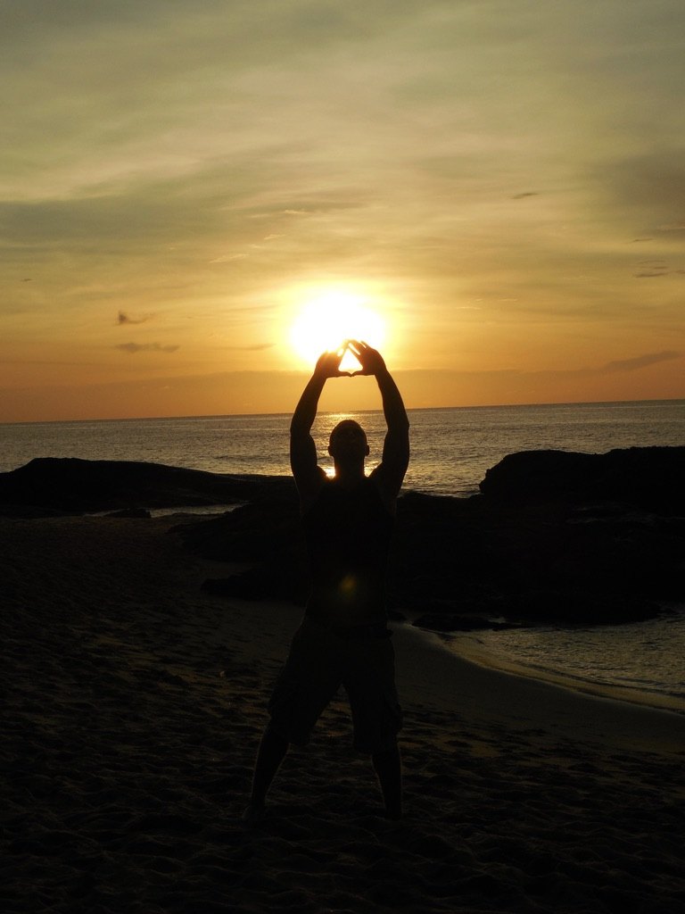 Daniel als Silhouette am Strand vor der untergehenden Sonne