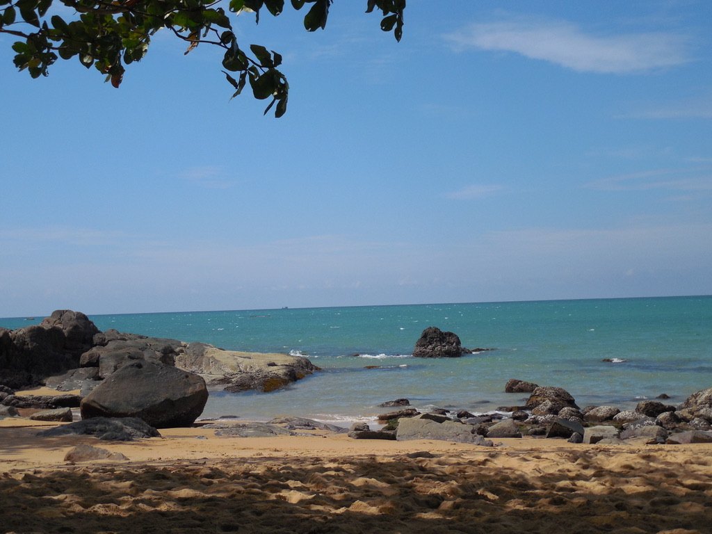 Strand mit Felsen und türkisem Meer in Khao Lak