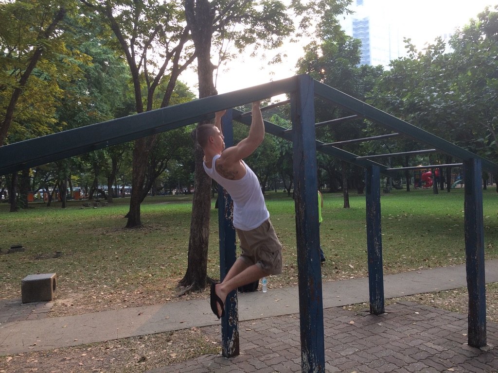 Daniel trainiert an einer Klimmzugstange im Park